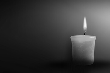 Candle burning in the black background. The concept of mourn, grief or mourning