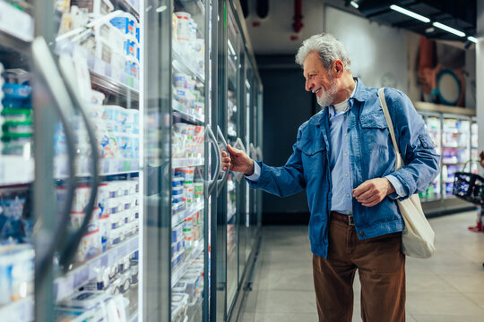 Senior man buying frozen product in grocery store