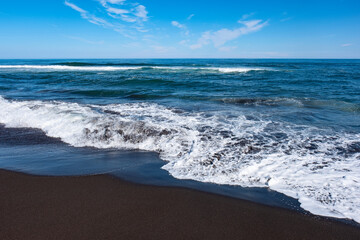 Petropavlovsk Kamchatsky Pacific Ocean beach with black volcanic sand and a big wave