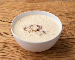 Mushroom soup in a bowl over wooden table