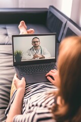 Woman lying on a sofa and talking with a doctor online using laptop. Telemedicine concept. - obrazy, fototapety, plakaty