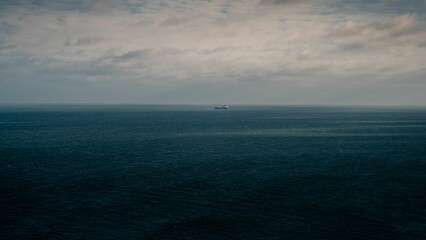 The blue cloudy sky and the Irish Sea merging into the horizon and a ship at a distance