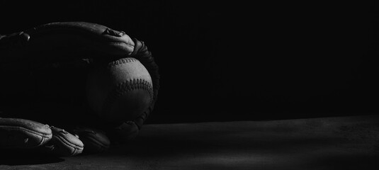 Low key lighting baseball equipment closeup for moody sports banner.