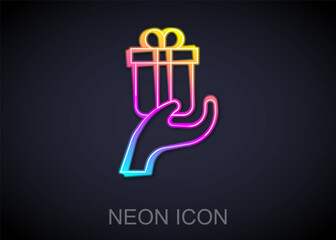 Glowing neon line Give gift icon isolated on black background. Gift in hand. The concept of giving and receiving a gift. Vector