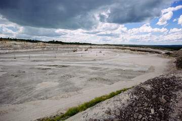 Chalk quarry pit with working excavators