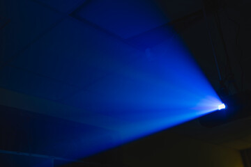 projector spotlight blue color , smoke texture background . light beam screening and glowing for...