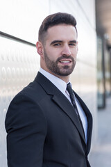 Fototapeta premium businessman in suit at silver building wall