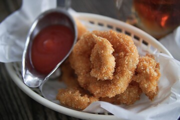 Closeup shot of a chicken nuggets with ketchup on the side