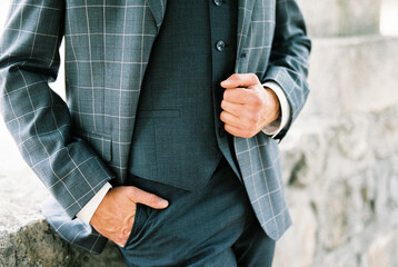 Man in a plaid suit with his hand in his pants pocket. Close-up