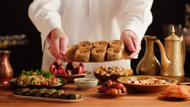 Turkish traditional food, sweet dish, Baklava close-up. Arabian cuisine, treats. Middle eastern national sugar dessert snack. Dolma, hummus, nuts and tabbouleh on table.