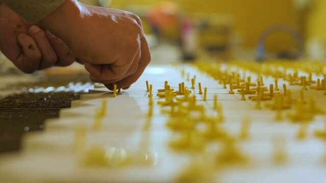 Installing ceramic floor tiles - measuring and cutting the pieces. The worker installs plastic crosses between ceramic tiles.