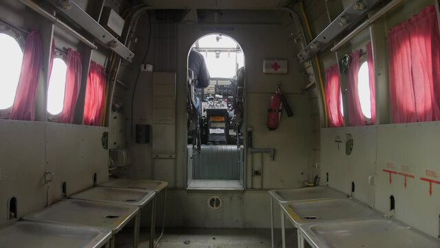 Through the fuselage, you can see how a man gets into the pilot's seat inside the cockpit of an old An-2 plane.