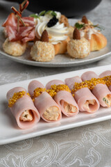 Stuffed ham rolls garnished with Dijon mustard. Plate on the festive table.