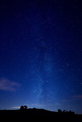 The trailing stars of the Milky Way rising above the dark silhouette of Honey Hill, Elkington...