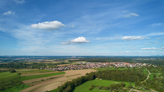 Aerial view of German small town in sunny afternoon with blue sky, Before agricultural area. Germany, Nurtingen, Reudern.