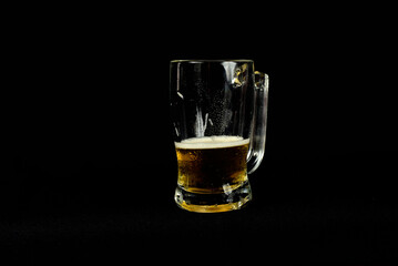 beer mug isolated on black background with half-drunk drink