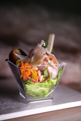 salad with meat and nuts in a plastic cup on the buffet