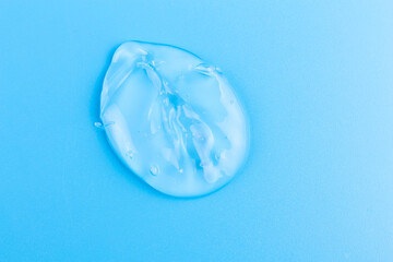 Moisturizing transparent face cream gel smeared isolated on blue background.