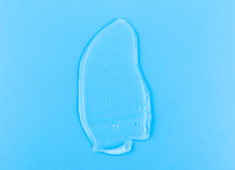 Moisturizing transparent face cream gel smeared isolated on blue background.