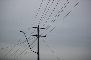 A silhouette of power lines on a dark gloomy day
