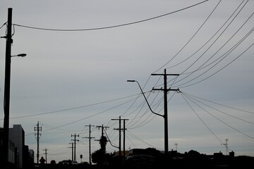 A silhouette of power lines on a dark gloomy day