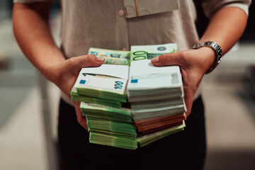 Bank employees holding a pile of paper banknotes while sorting and counting inside bank vault....