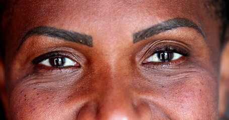 African woman opening eyes smiling at camera. Female eyes staring