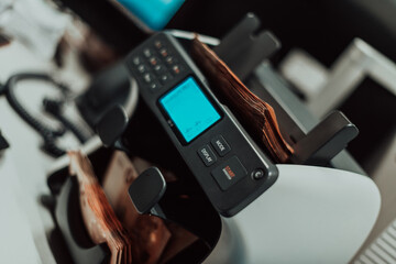 Bank employees using money counting machine while sorting and counting paper banknotes inside bank vault. Large amounts of money in the bank