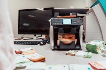 Sorted banknotes placed on the table after it is counted on the electronic money counting machine