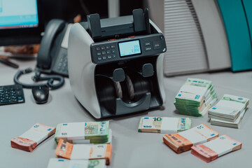 Sorted banknotes placed on the table after it is counted on the electronic money counting machine