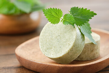 Nettle solid shampoo pieces or homemade natural organic soap bars, fresh green nettle leaves....
