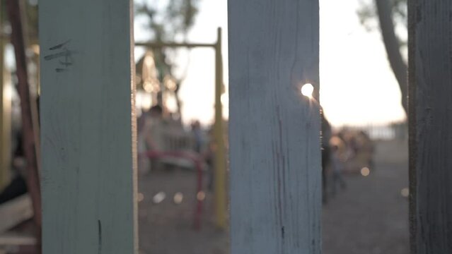 Slow Motion Of Kids Playing In The Yard Captured From Behind The Wooden Fence