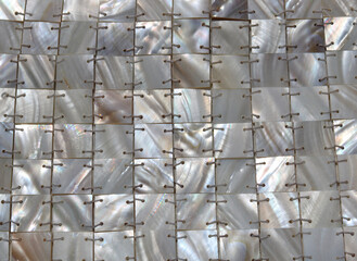 Full frame background of mother of pearl stitched in square geometric design
