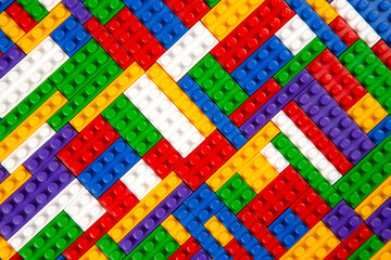 Abstract background texture of colored constructor blocks. Background of colorful plastic part of constructor. Pile of colored toy bricks.