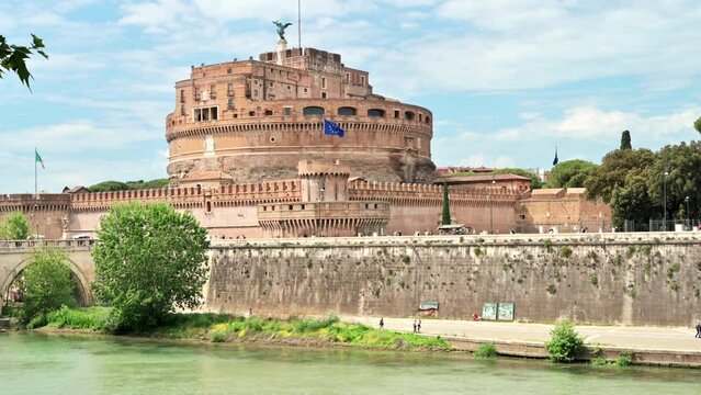 View of the Tiber River and Castle of the Holy Angel in the center of Rome, Italy. Embankment street with people