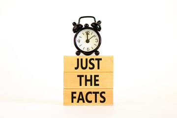 Just the facts symbol. Concept words Just the facts on wooden blocks on a beautiful white table white background. Black alarm clock. Business and just the facts concept. Copy space.