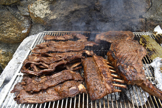 Image of a barbecue with pork ribs and meat on the grill