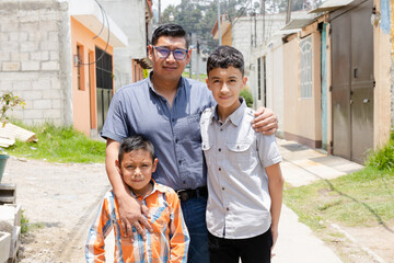 Latin dad with his children outside his house-Hispanic father proud of his children-father of a young family - obrazy, fototapety, plakaty