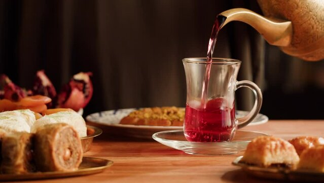 Turkish sweet food. Arabian cuisine. Baklava, nuts, pismaniye and tea close-up. Middle eastern national sugar treats, dessert snack.