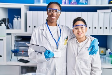 African american mother and son scientists smiling confident standing together laboratory