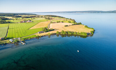 Aerial view over the lake penisula with a single boat in the bay - 516464641