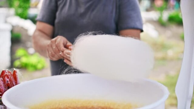 Seller making cotton candy on the counter. Slow motion