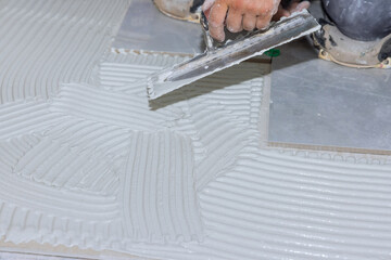 For laying tile on a concrete floor, mortar is troweled onto the floor in order to apply adhesive...