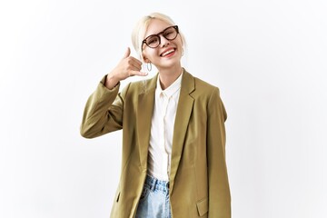 Beautiful caucasian business woman standing over isolated background smiling doing phone gesture with hand and fingers like talking on the telephone. communicating concepts.