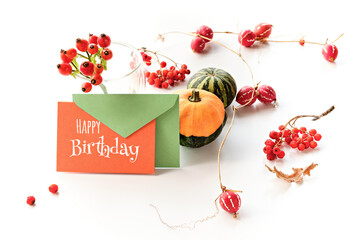 Autumn decorations, card with text Happy Birthday text. Natural decorative Fall pumpkins and red...