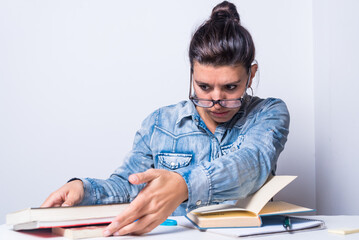 young latina woman, with glasses arranging books, study concept