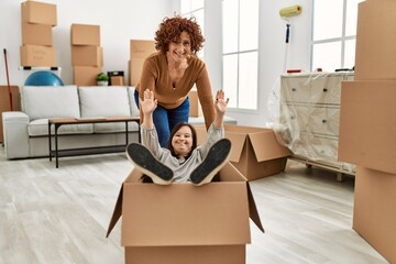 Mature mother and down syndrome daughter moving to a new home, having fun inside box