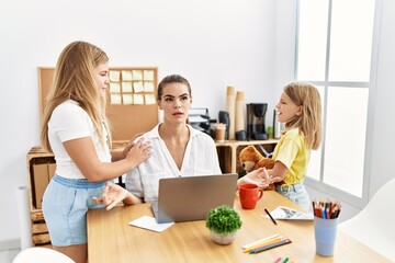 Fototapeta premium Mother and daughters business worker doing yoga exercise while girls scream at office