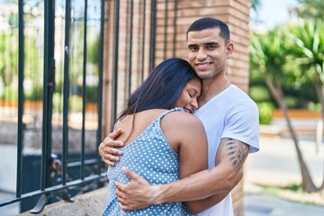 Obraz premium Man and woman couple smiling confident hugging each other at street