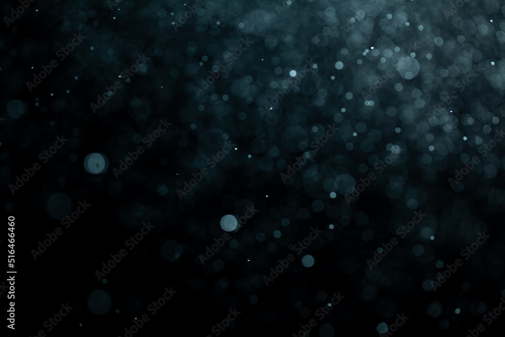 Wall mural glowing blue highlights. wallpaper pattern. blue sparkling spots. dust or fog on a black background.